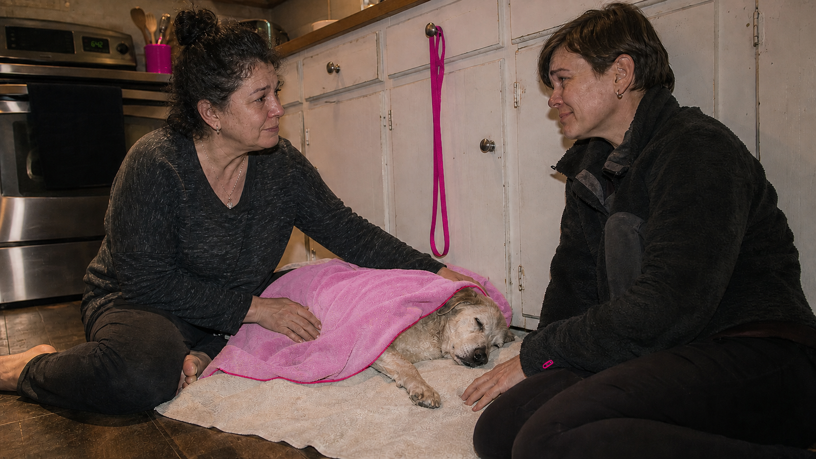 Two family members sit beside their elderly dog after its death and look to each other